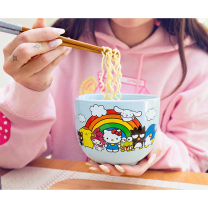 Person holding Sanrio ramen bowl with noodle lifted by bamboo chopsticks, wearing a pink hoodie