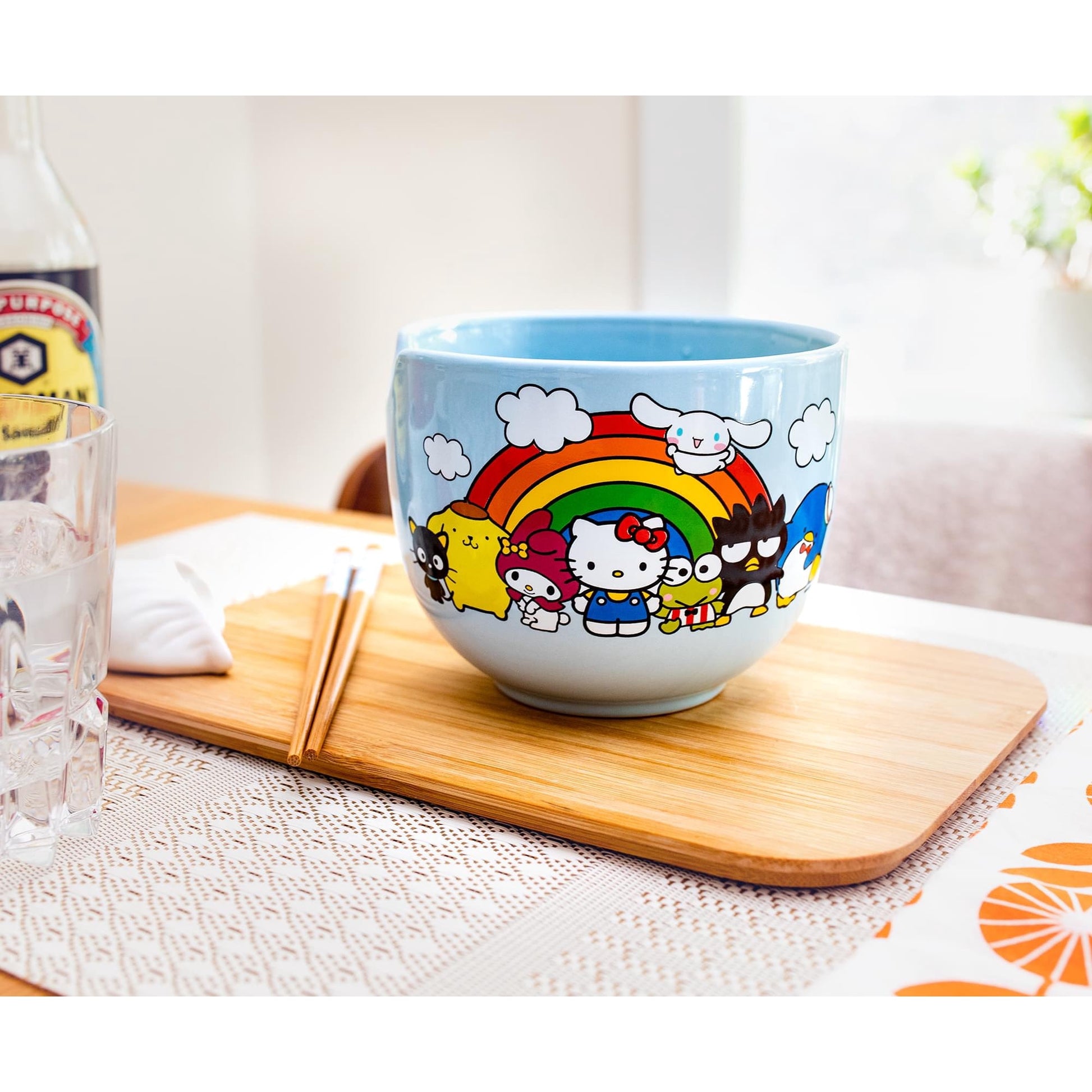 Sanrio ramen bowl with bamboo chopsticks placed on a wooden board in table setting with soy sauce bottle in background