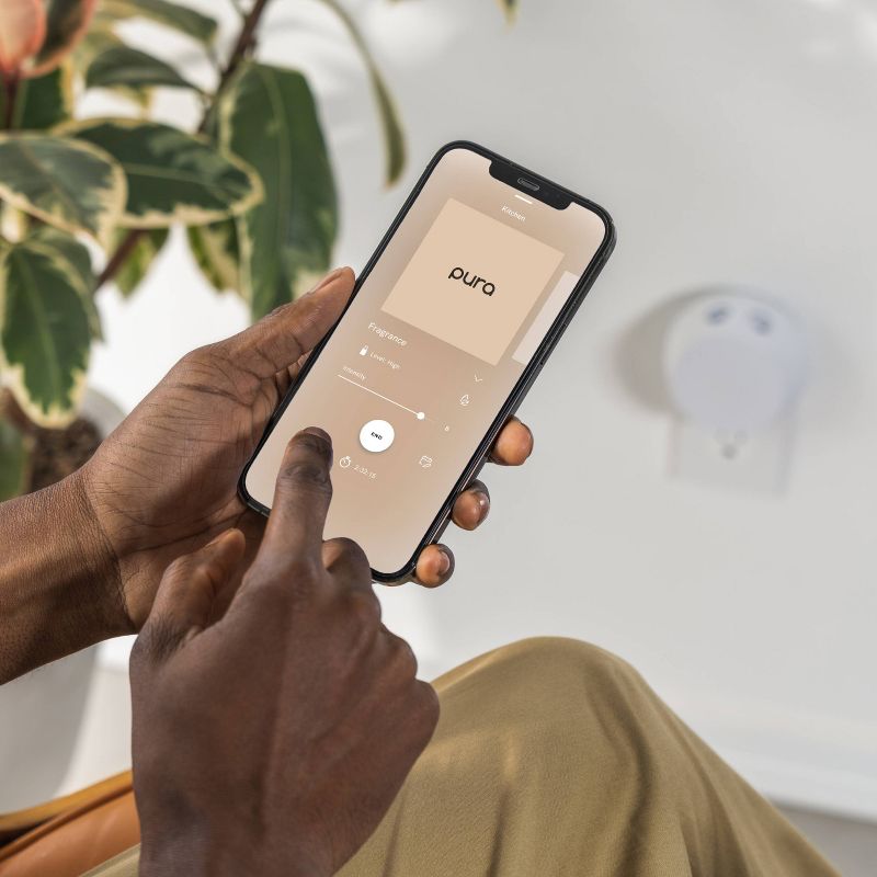 Person controlling Pura Smart Scent fragrance intensity and settings on smartphone app