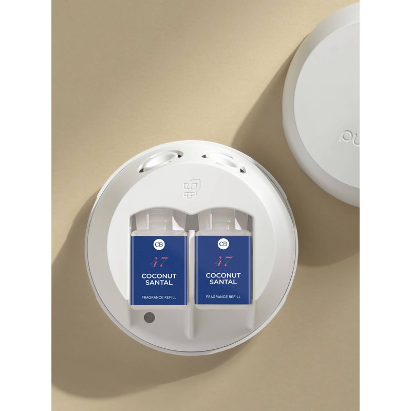 Two Pura Coconut Santal fragrance refill bottles inserted in the white Pura Smart Scent device