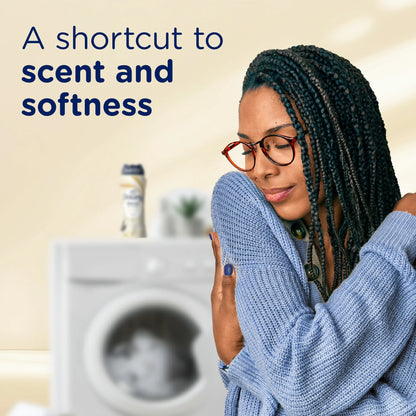 Two hands holding Downy Blends fabric softener with warm vanilla scent label  