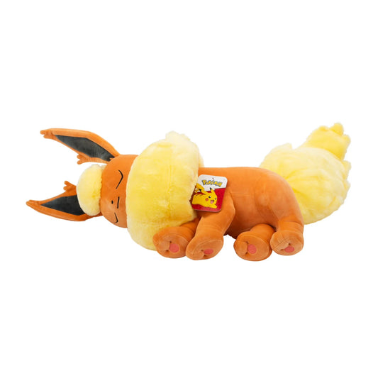 Close-up of Flareon plush sleeping peacefully with eyes closed and fluffy tail curled  